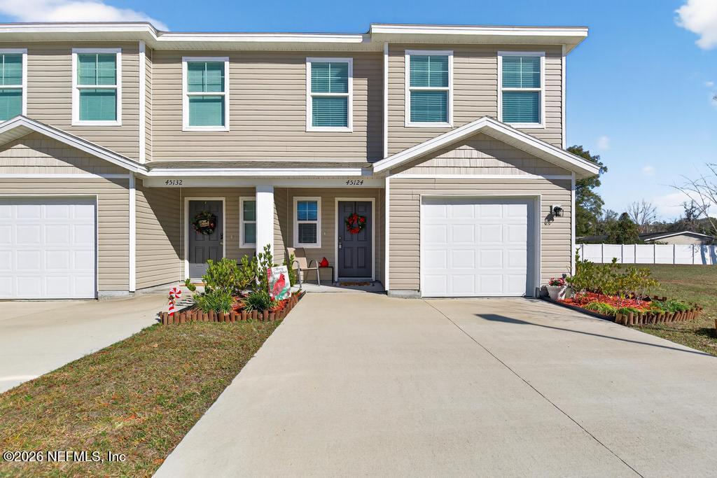 45124 Red Brick Drive Callahan, FL 32011 - Photo 1 of 54 a front view of a house with a yard and potted plants