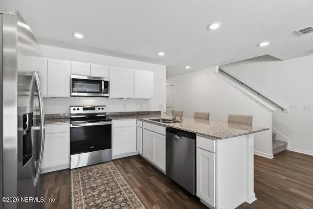 a kitchen with a sink stainless steel appliances and cabinets