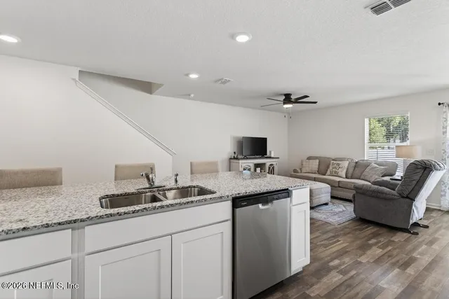 a living room with granite countertop furniture and a flat screen tv