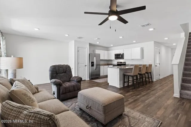 a living room with furniture and kitchen view