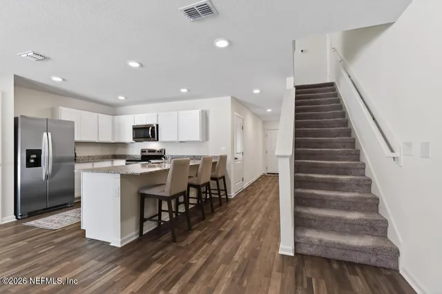 a kitchen with a refrigerator and white cabinets