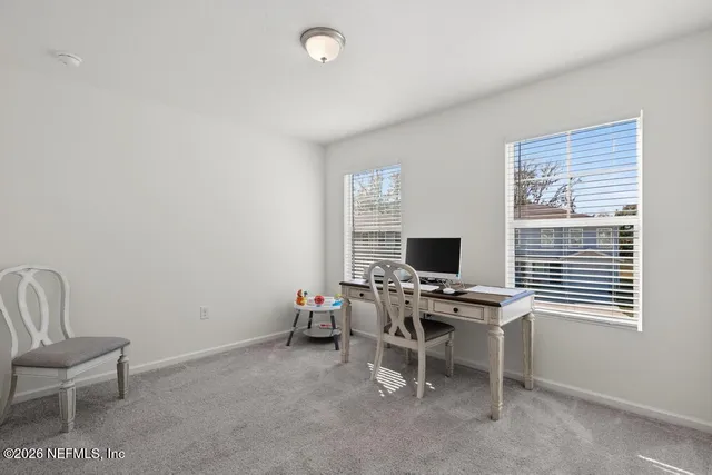 a view of a workspace with furniture and a window