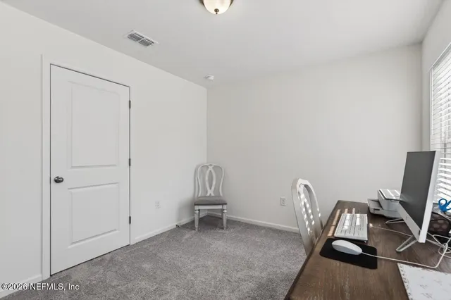 a view of a workspace with furniture and a window