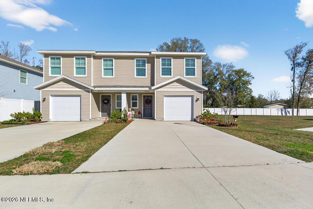 45124 Red Brick Drive Callahan, FL 32011 - Photo 3 of 54 a front view of a house with a garden and yard