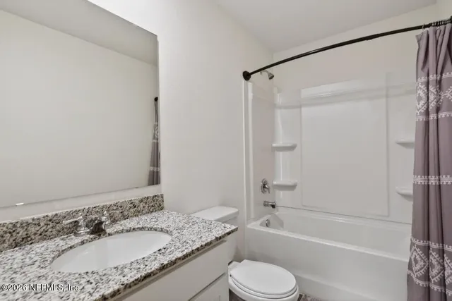 a bathroom with a granite countertop toilet sink and shower