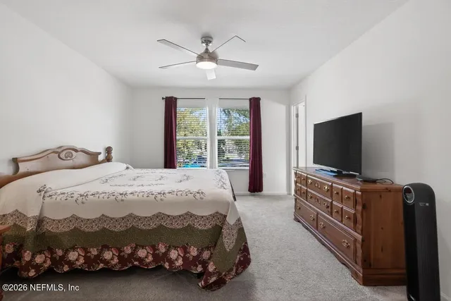 a bedroom with a bed and a flat screen tv on dresser