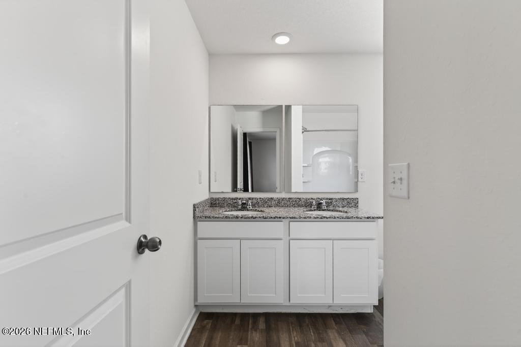 45124 Red Brick Drive Callahan, FL 32011 - Photo 41 of 54 a bathroom with a granite countertop sink a mirror and a vanity