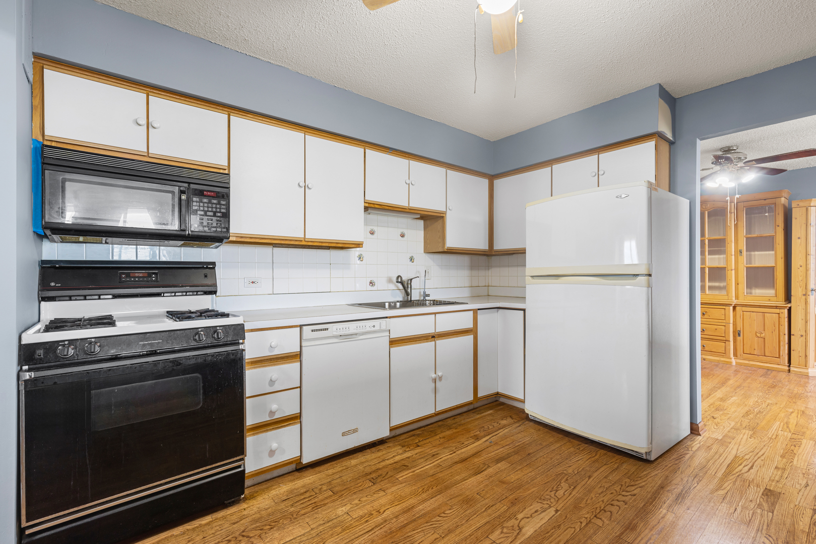 8815 West Golf Road, Unit 7A Niles, IL 60714 - Photo 12 of 26 a kitchen with granite countertop a refrigerator stove and microwave