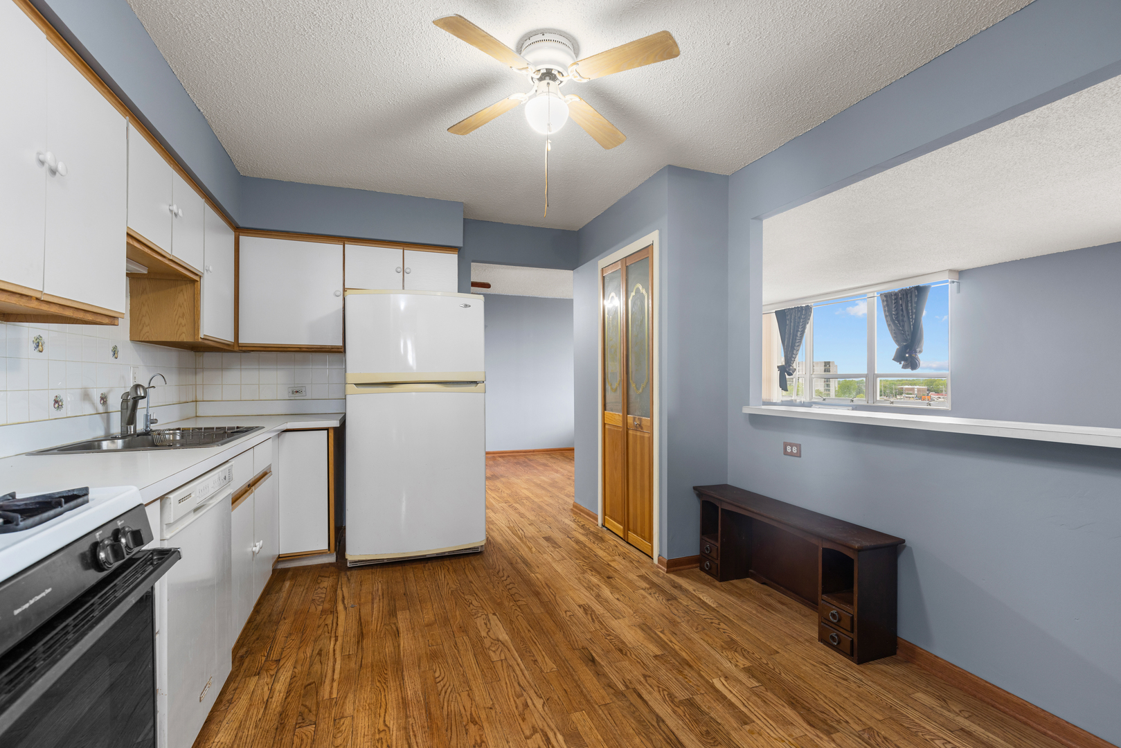8815 West Golf Road, Unit 7A Niles, IL 60714 - Photo 13 of 26 a kitchen with wooden floor and stainless steel appliances