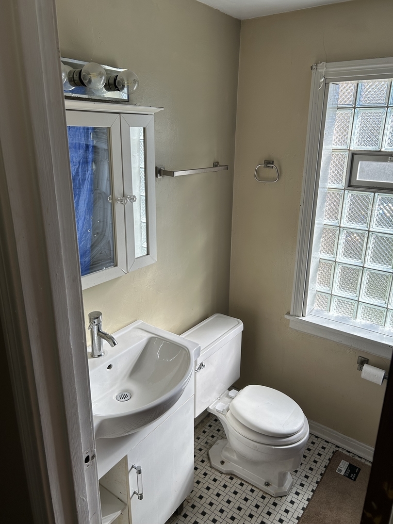 519 East 109th Street Chicago, IL 60628 - Photo 5 of 8 a white toilet sitting next to a bathroom sink