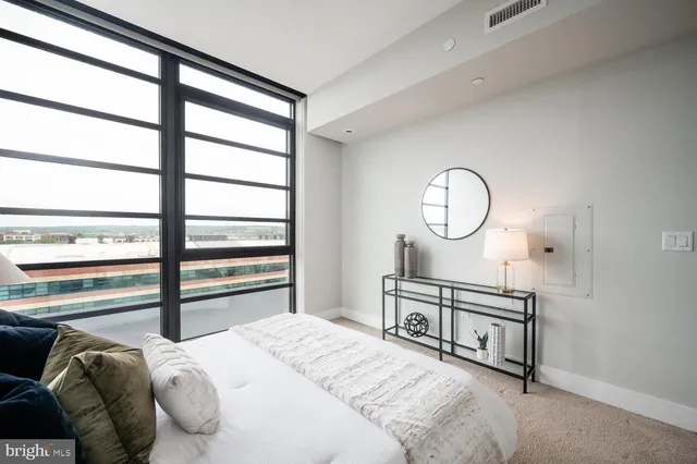 a bedroom with a bed a mirror and a window