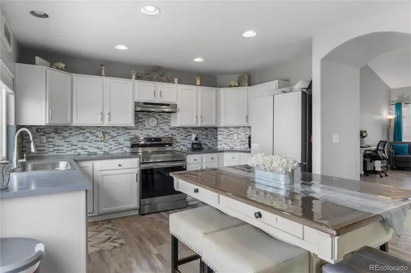 a large kitchen with stainless steel appliances granite countertop a stove a sink and a refrigerator