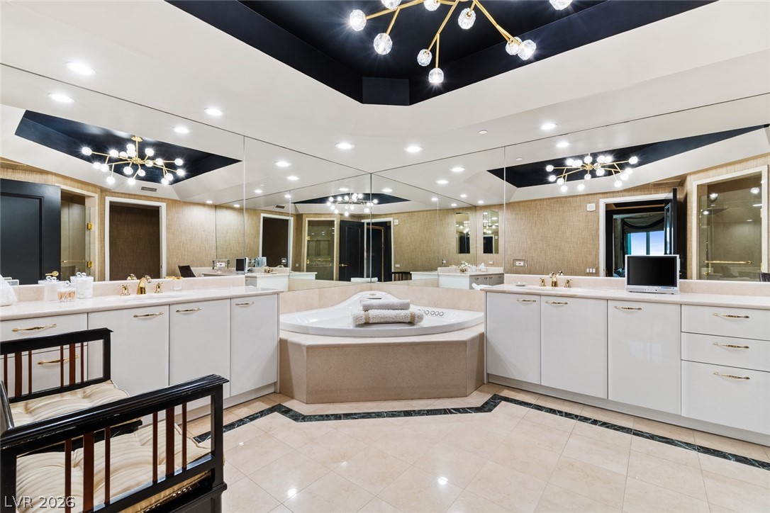 2857 Paradise Road, Unit 602 Las Vegas, NV 89109 - Photo 18 of 33 Polished tile flooring and mirrored walls frame a sunken soaking tub beneath architectural ceilings.