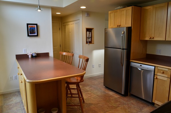 3 West Whitehall Road Amesbury, MA 01913 - Photo 10 of 18 a kitchen with stainless steel appliances granite countertop a refrigerator a sink a stove a dining table and chairs