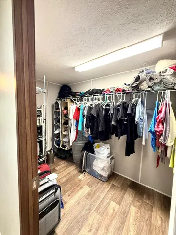 a view of walk in closet with clothes and shoes