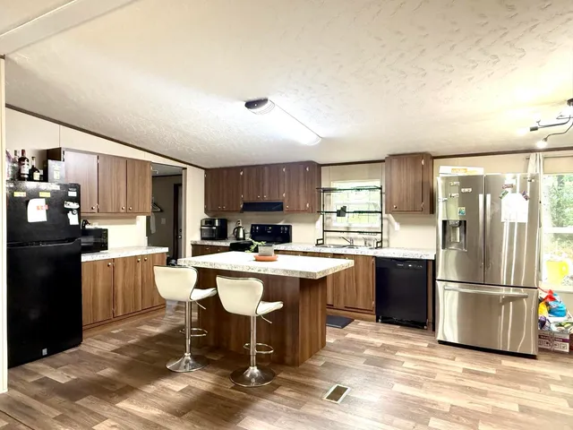 a kitchen with a sink a kitchen island and stainless steel appliances