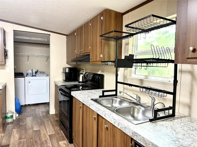 a kitchen with stainless steel appliances granite countertop a sink a stove and a wooden floors