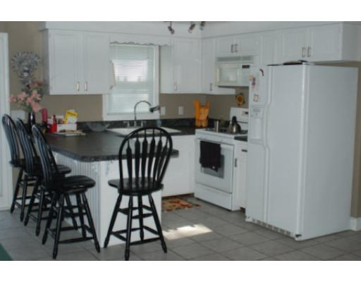 122 Sarah Sherman Road Rochester, MA 02770 - Photo 2 of 4 a kitchen with stainless steel appliances a table chairs and a refrigerator