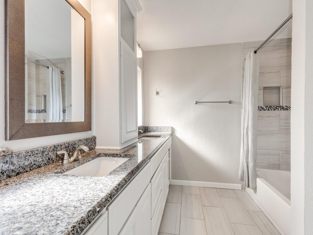7335 Reed Road Azle, TX 76020 - Photo 22 of 36 a bathroom with a granite countertop sink mirror and shower
