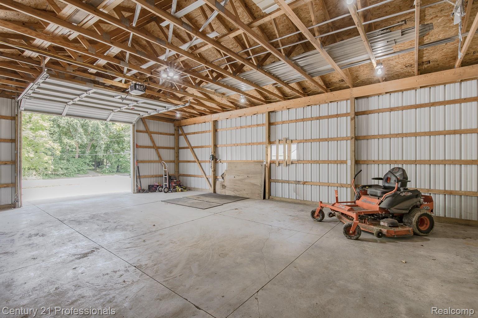 1790 Kent Road Ortonville, MI 48462 - Photo 31 of 64 Spacious outbuilding featuring a concrete floor, exposed wood beam ceiling, metal siding, and an overhead garage door