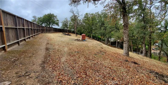 a view of a yard with wooden fence