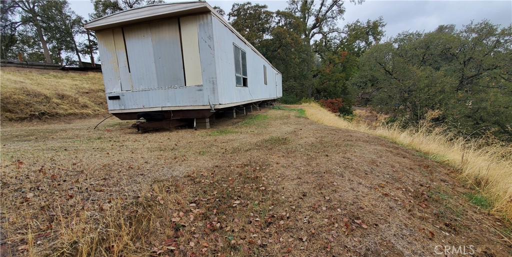 7126 Coyote Point Corning, CA 96021 - Photo 14 of 18 a view of backyard with large trees and wooden fence