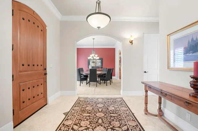 a dining room with furniture a chandelier and wooden floor