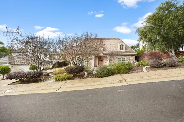 a front view of a house with a yard and mountain view