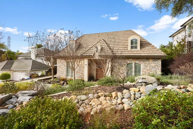 a view of a backyard with table and chairs potted plants and wooden fence