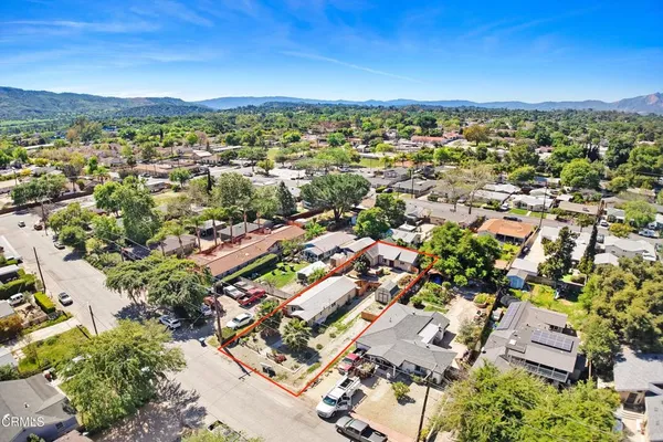 an aerial view of residential houses with outdoor space and trees