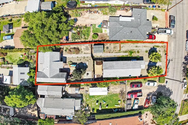 an aerial view of residential houses with outdoor space and trees