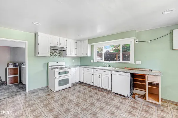a kitchen with stainless steel appliances a stove a sink and a refrigerator