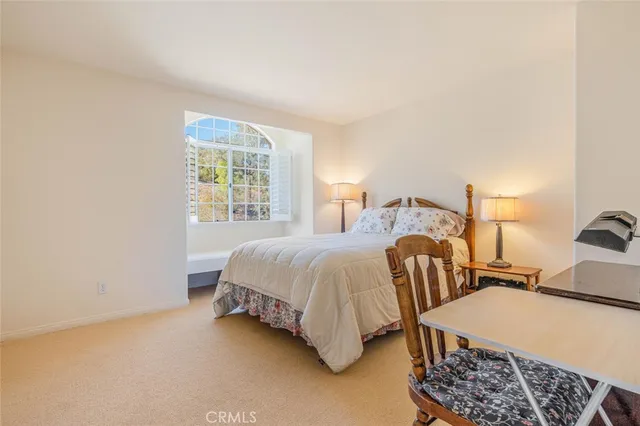 a spacious bedroom with two beds and painting on the wall