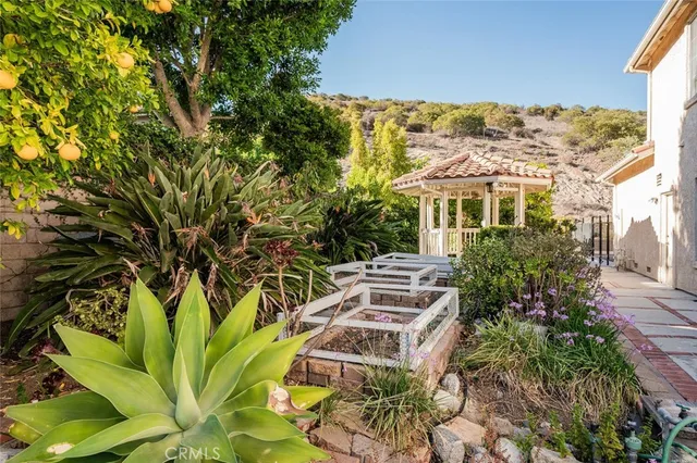 a view of a white house with a yard and potted plants