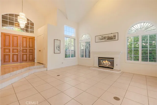 an empty room with windows and fireplace