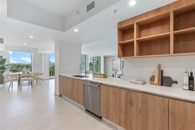 a living room with furniture a dining table and a refrigerator