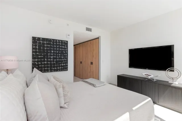 a large white kitchen with a large window and stainless steel appliances