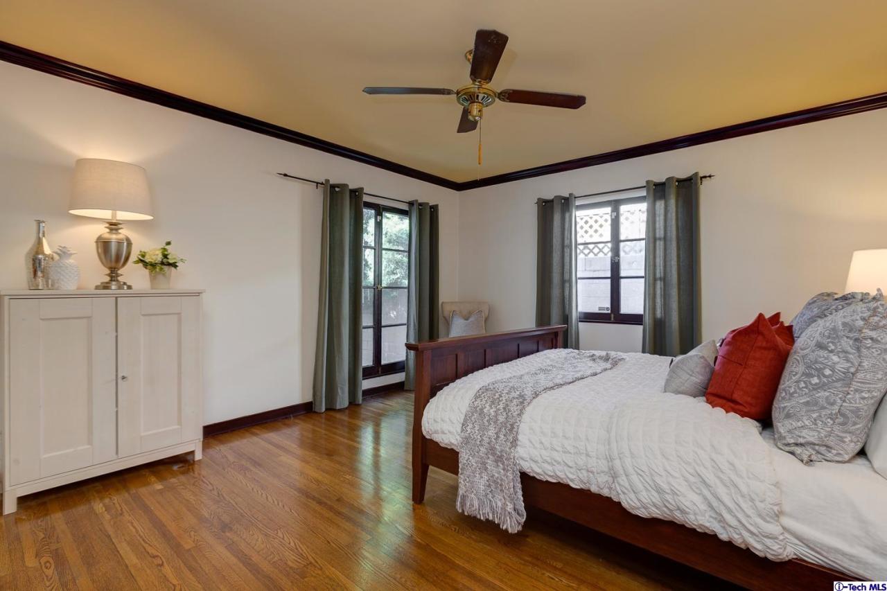 3301 Mount Curve Avenue Altadena, CA 91001 - Photo 25 of 29 a bedroom with a large bed chandelier and a window