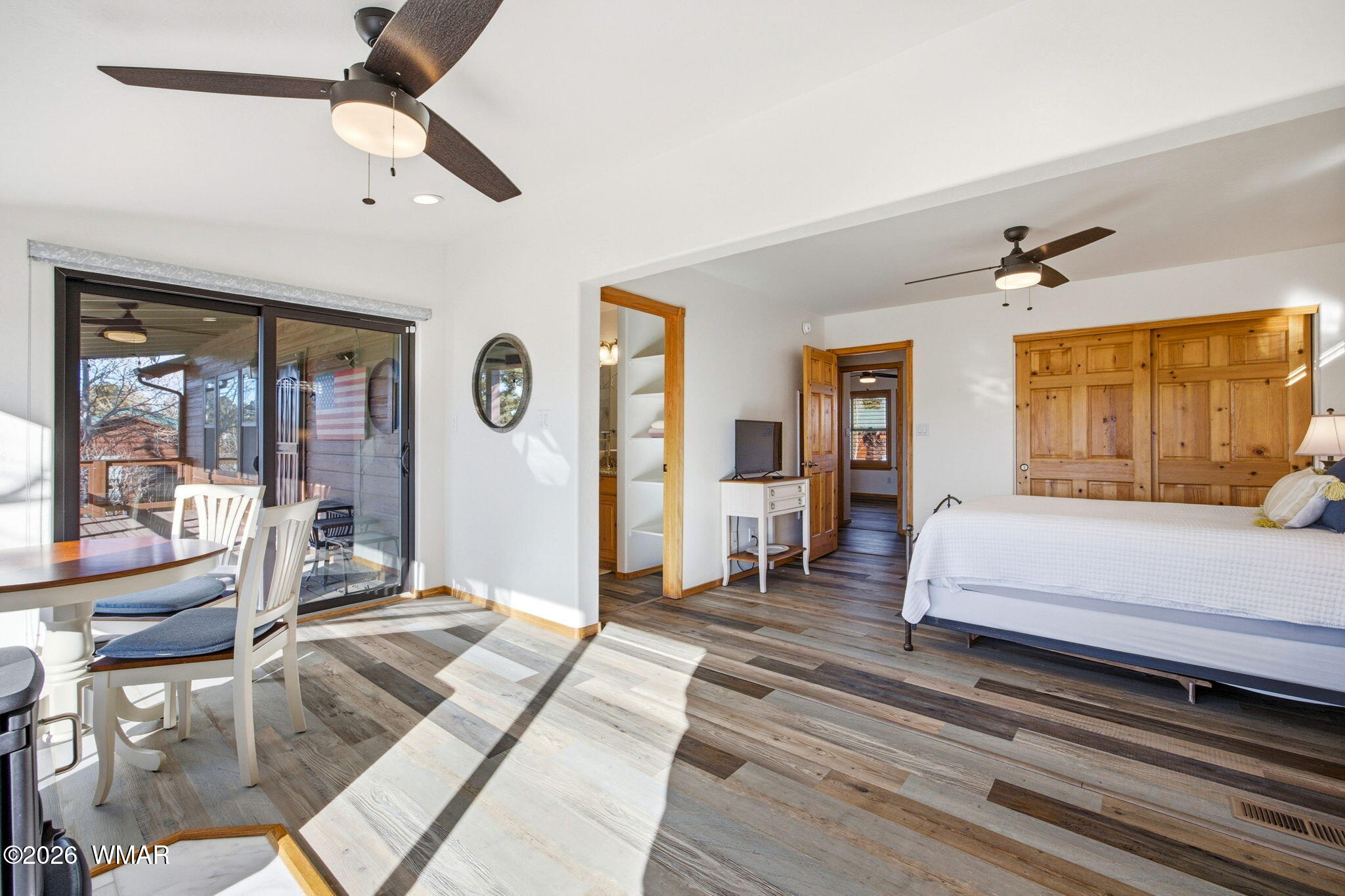 2660 Palomino Trail Overgaard, AZ 85933 - Photo 13 of 60 a spacious bedroom with a large bed a chandelier and windows