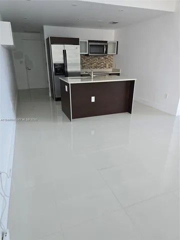 a room with stainless steel appliances wooden cabinets and entryway