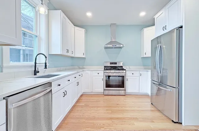 a kitchen with stainless steel appliances a stove refrigerator sink and cabinets