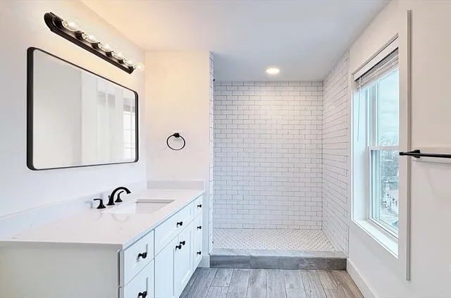 a bathroom with a double vanity sink a mirror and a shower
