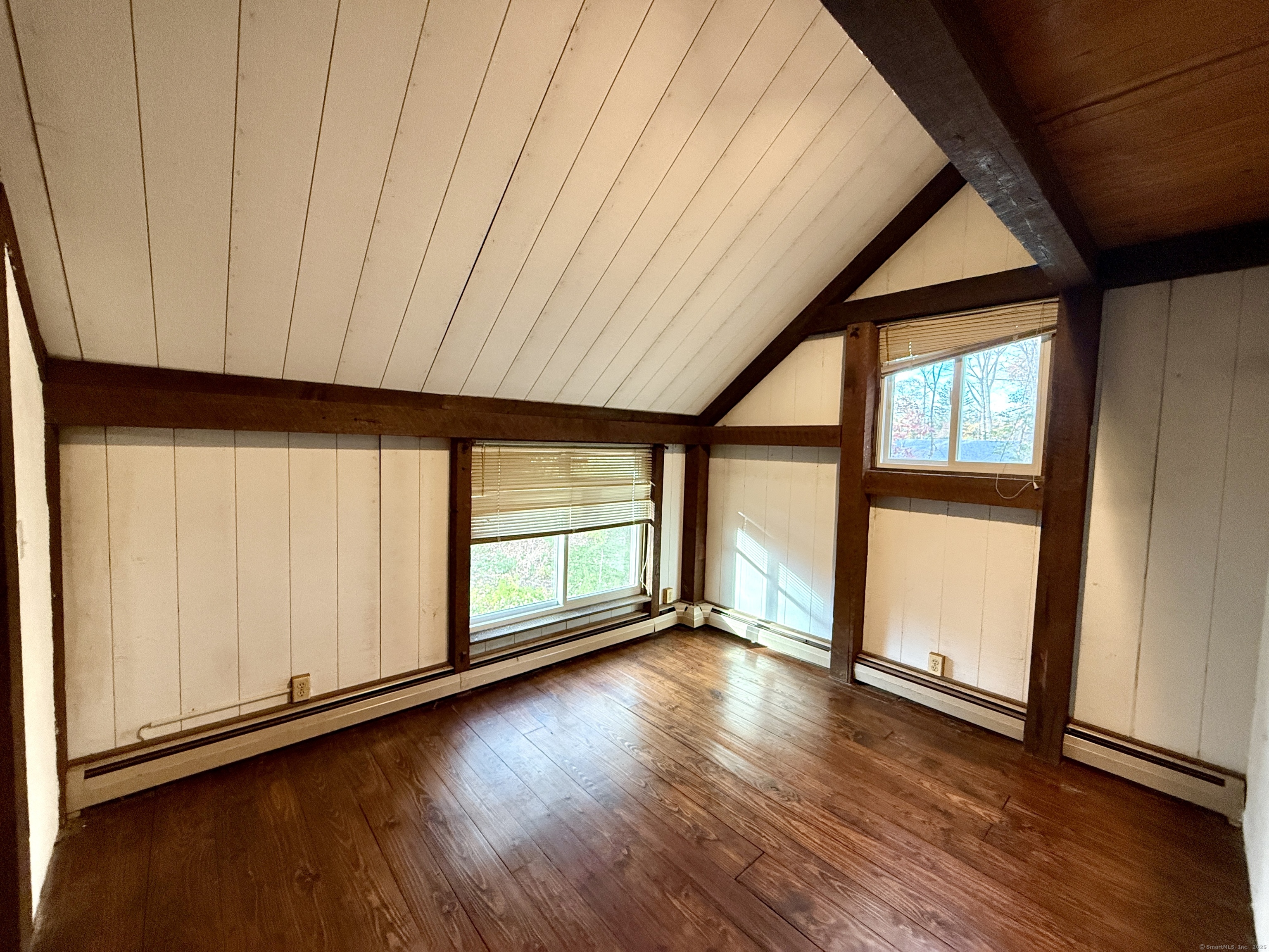 102 Krapf Road Ashford, CT 06278 - Photo 33 of 39 an empty room with wooden floor and windows with curtains