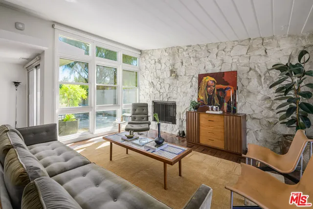 a living room with furniture a rug and a window