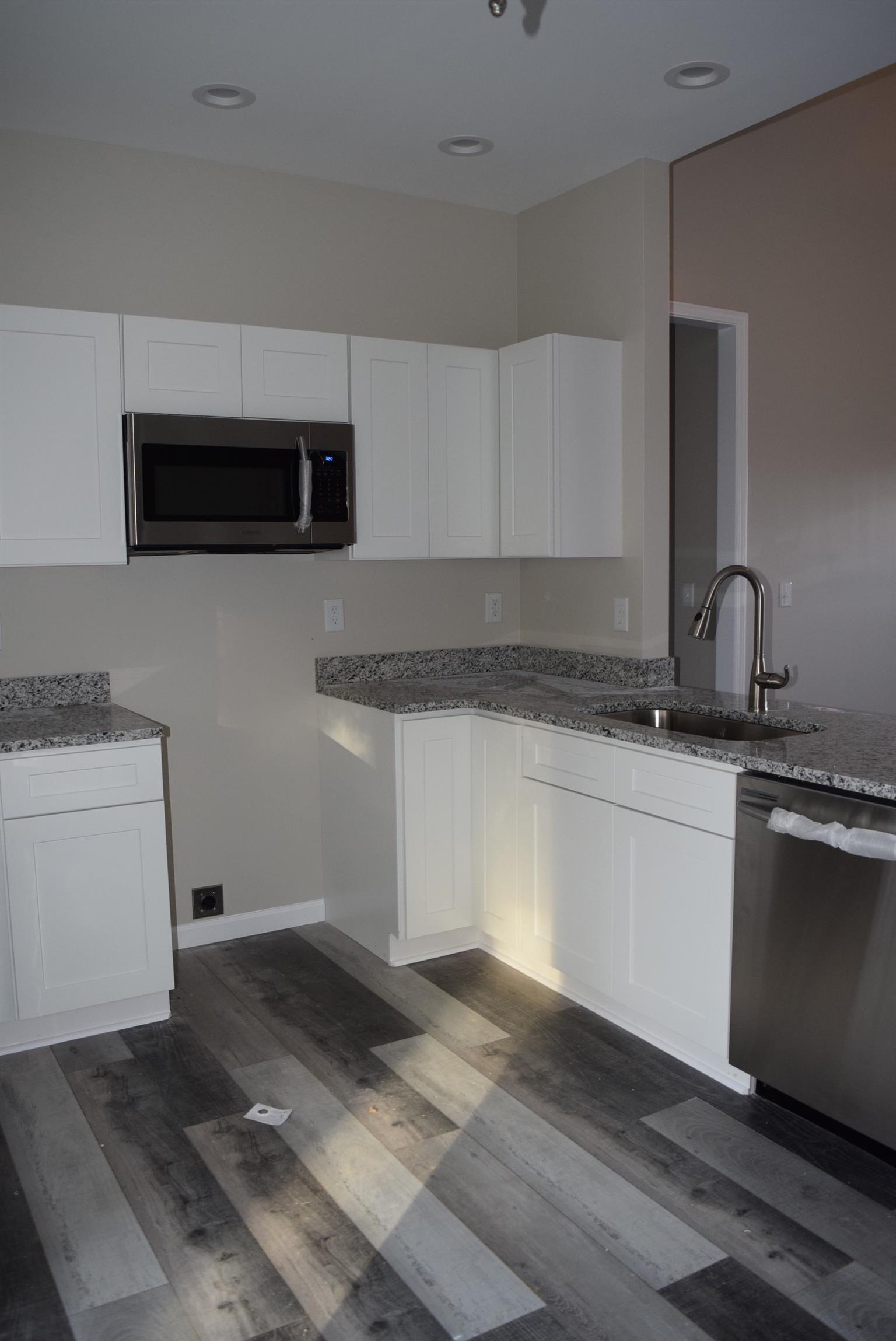 2401 Sylvia Road Dickson, TN 37055 - Photo 8 of 11 Kitchen with granite tops on white shaker cabinets. Includes stove, microwave, and dishwasher
