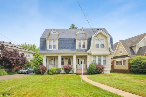 a front view of a house with a garden and yard