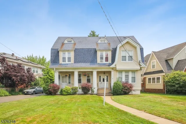 a front view of a house with a garden and yard