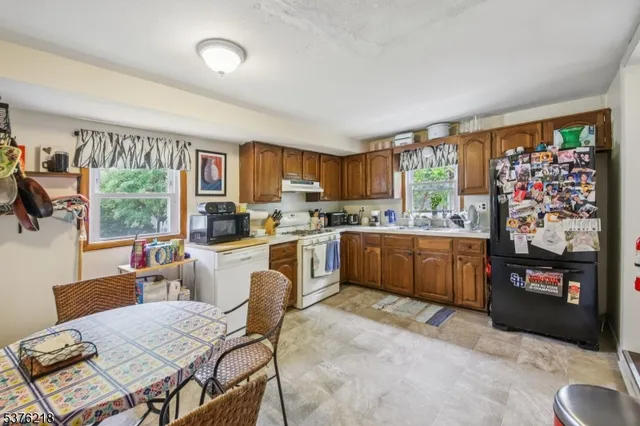 a kitchen with a table chairs microwave and cabinets