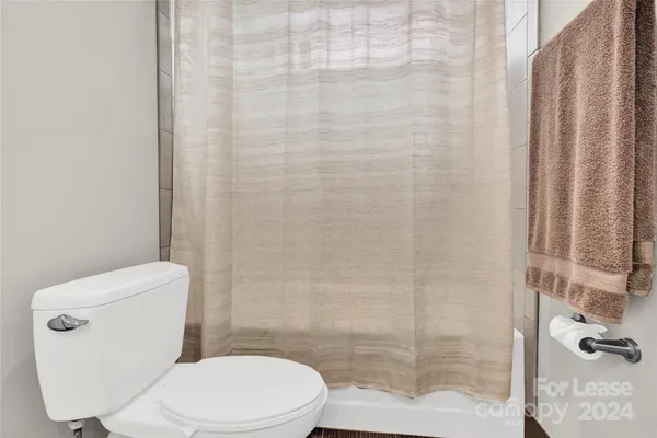 a white toilet sitting next to a shower