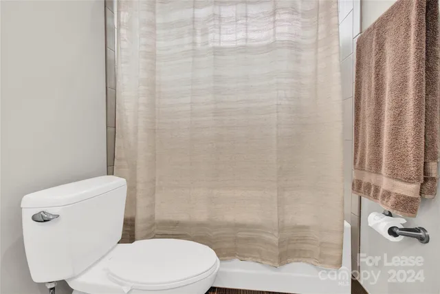 a white toilet sitting next to a shower